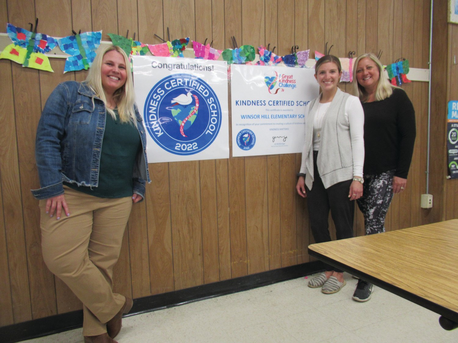 NATIONAL NICHE: Winsor Hill Principal Dr. Amy Burns (left), Behavorial Specialist Briana Bielecki and Health/Physical Education Teacher Susan Parillo are smiles after hanging the banner that designates the Johnston elementary school as a Certified Kindness School.